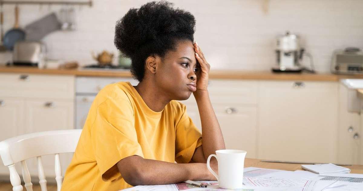 Mulher pensativa na cozinha, sentindo que precisa mudar